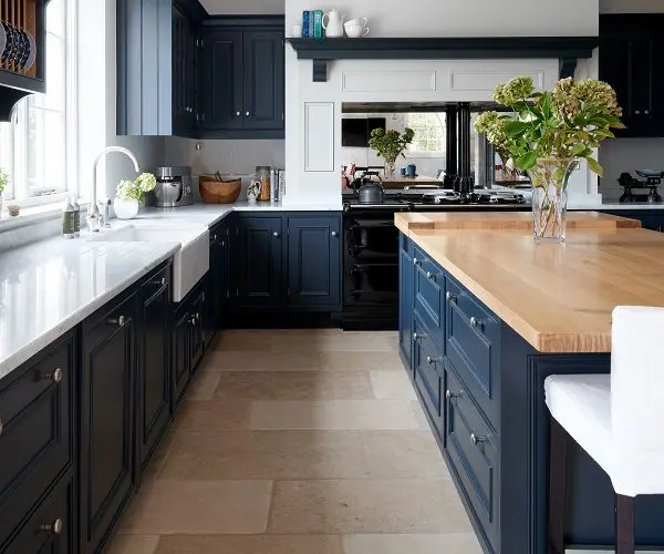Kitchen with fitted blue units and white marble surfaces