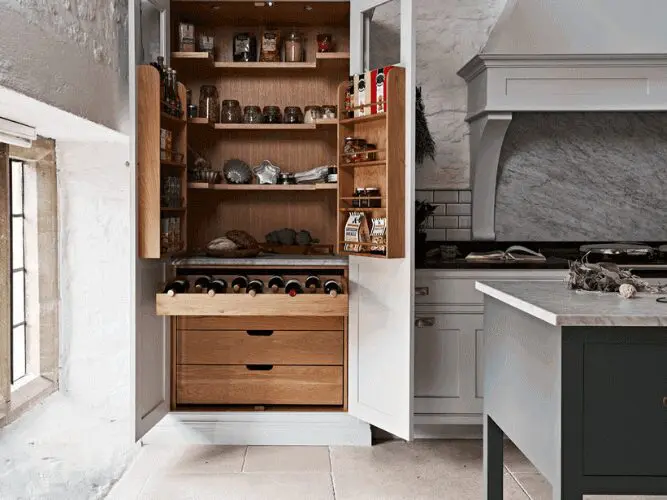 Long shot of an open kitchen unit featuring food and wine.