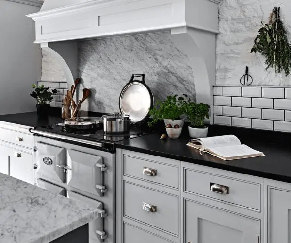 Angled shot of white shaker kitchen units and black work top
