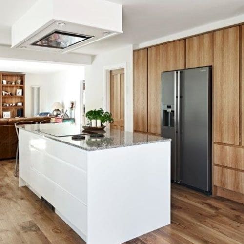 Modern kitchen with bespoke wooden storage and fitted refrigerator