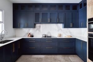 Dark blue kitchen units and white marble surfaces.