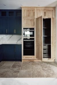 Bespoke kitchen units with granite surfaces and wooden fixtures