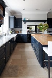 Kitchen with fitted blue units and white marble surfaces