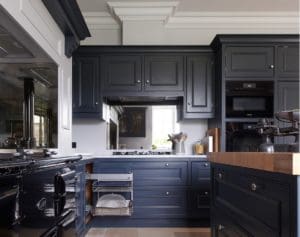 Dark blue kitchen units with wooden and marble surfaces