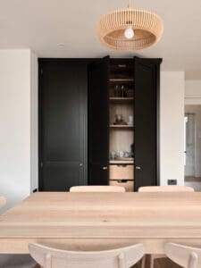 Wooden table with black fitted cupboards
